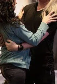 Two actors embracing during a rehearsal